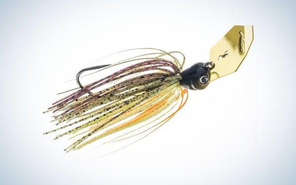 A fish bait with many colorful threads and a gold metal clip in it.