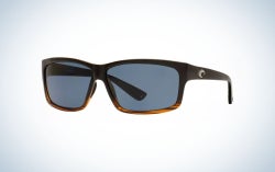 A pair of sunglasses with a black and brown frame and structure and two lenses in light translucent blue.