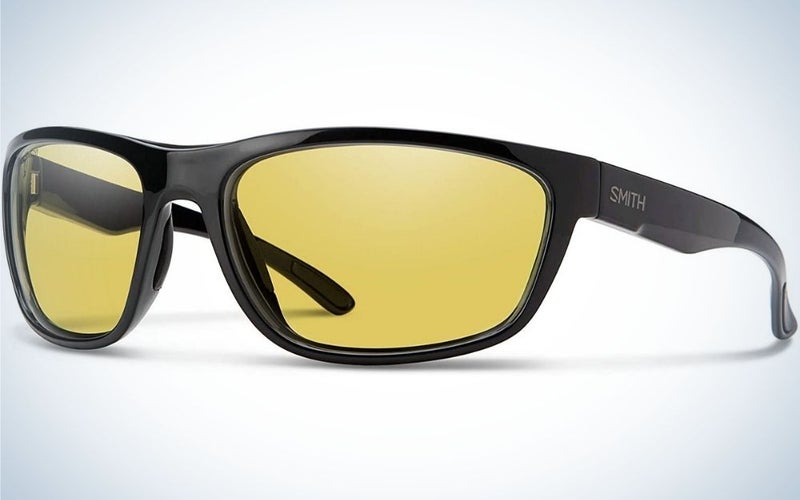 A pair of sunglasses with a black frame and structure and two lenses in bright neon yellow.