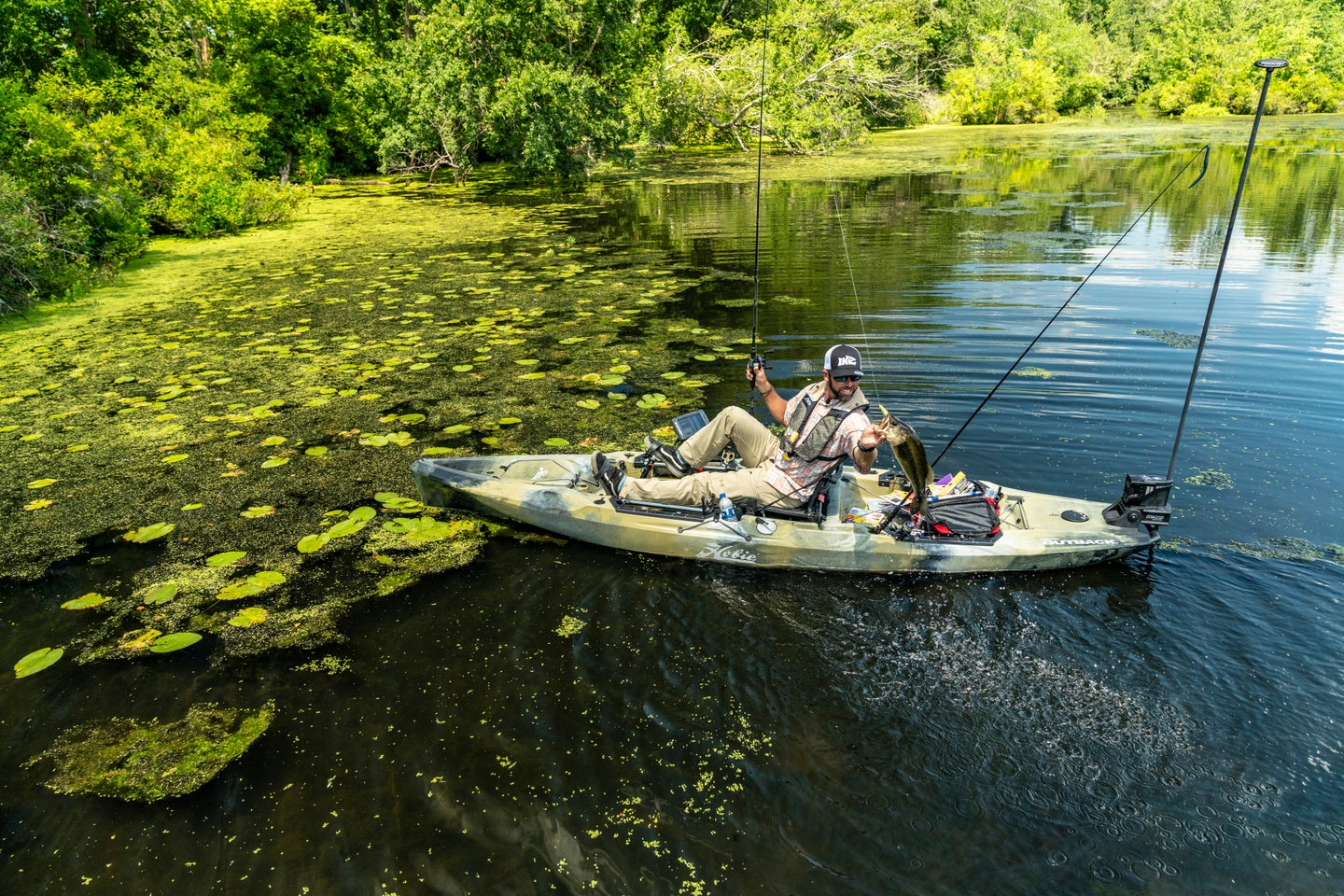 Fisherman hold bass on a Hobie fishing kayak