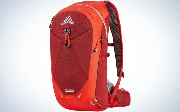 A backpack with a bright orange color and a large pocket with a zipper in front of it.