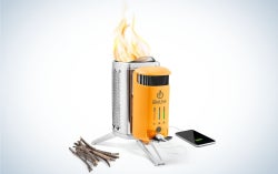 BioLite CampStove 2+ with a bundle of sticks to the left and a phone to the right