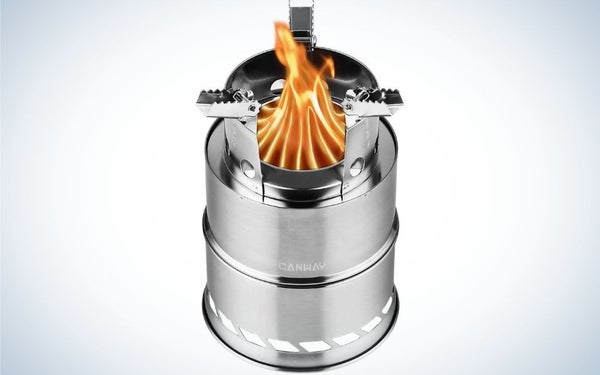 A silver-colored camping stove in the shape of several cylinders of different sizes on top of each other and a flame container that stands in the center of the stove.
