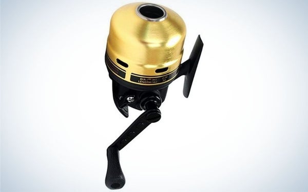 A spincast reel with a gold round head and black body with a black lever underneath.