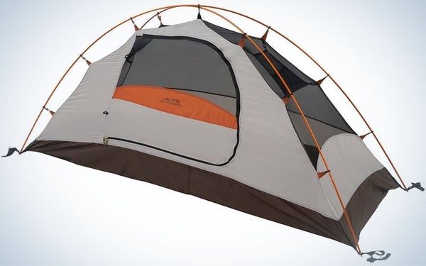 A green camping tent with orange and blue parts on it, as well as two ropes that are attached to the orange tent from above.