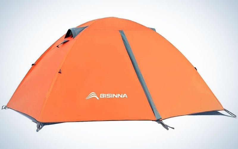 A small camping tent with an oval shape which is all orange with some small blue markings.