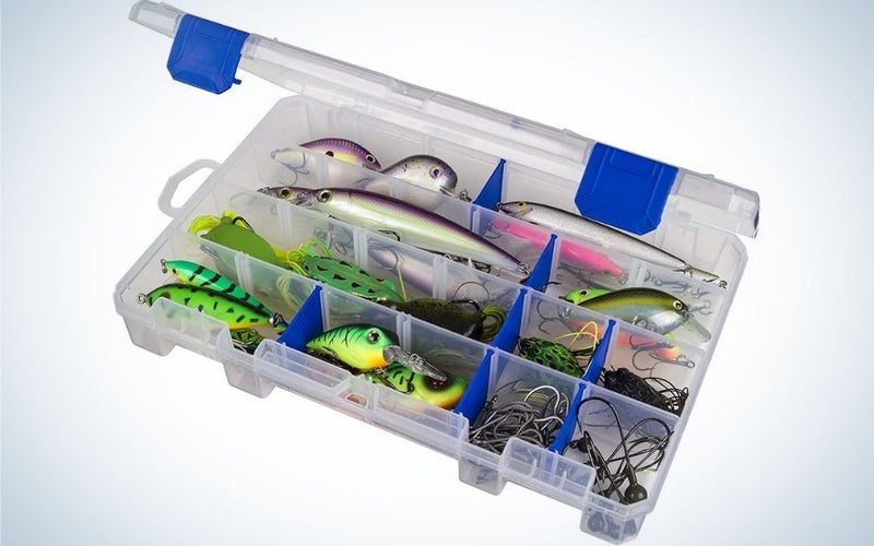 A transparent plastic box with some blue parts, which is open and inside it several different baits for catching fish.