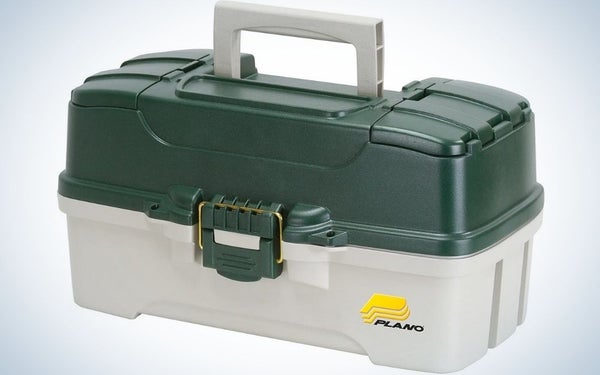 A plastic box in the shape of a small square suitcase in green and beige, as well as a holder on top of it.