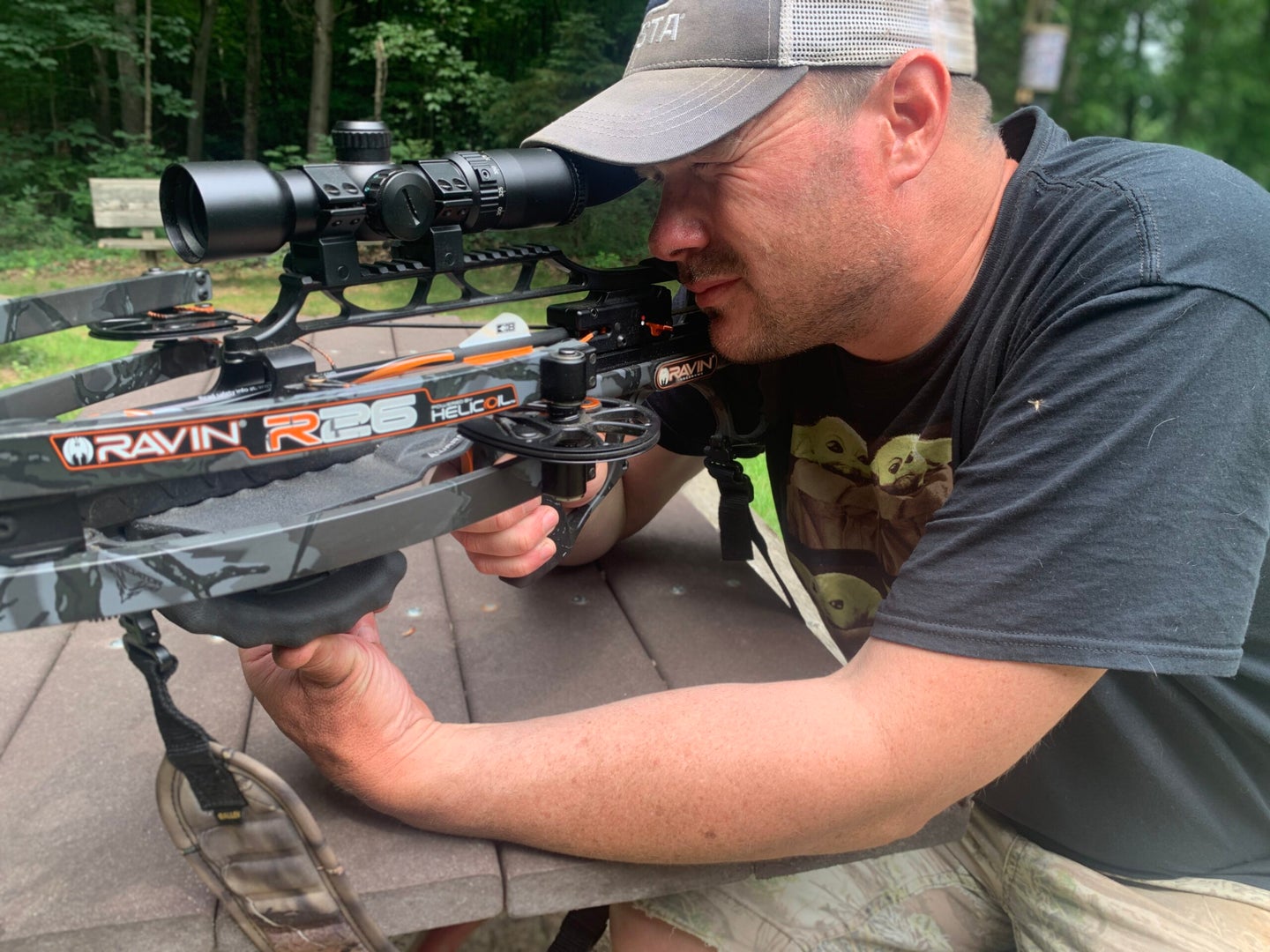 Crossbow shooter looks through a Ravin 450, a best crossbow scope for hunting.