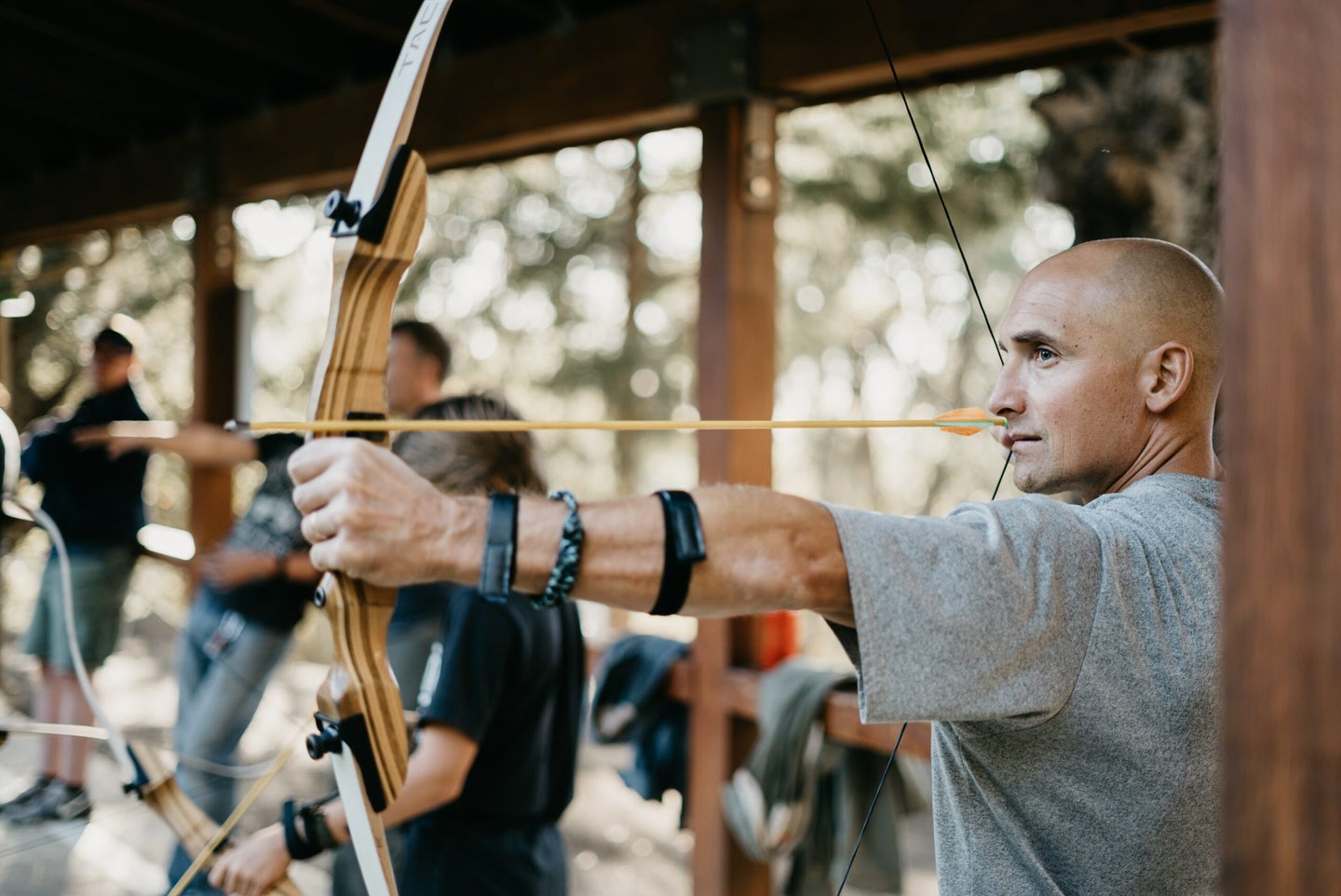man shooting recurve bow