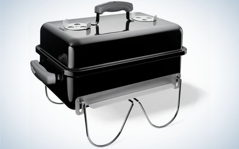 A large portable grill in the shape of a wide black and rectangular suitcase.