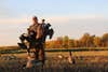 hunter retrieves Canada geese from an ag field.