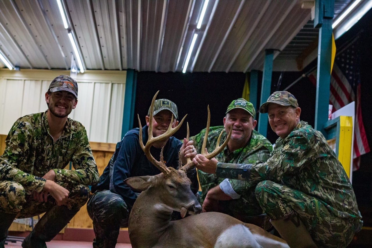 group of men pose with buck