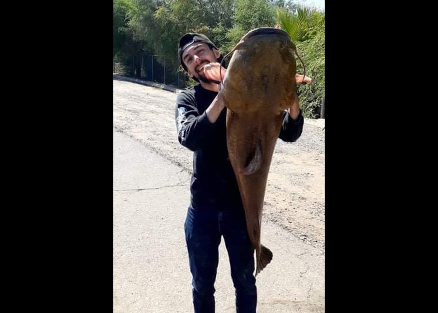 Man holds large catfish vertically