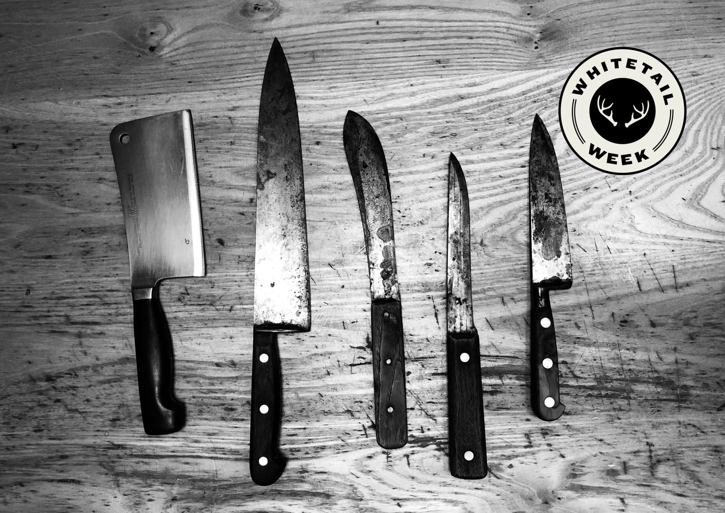 set of knives on a wooden table.