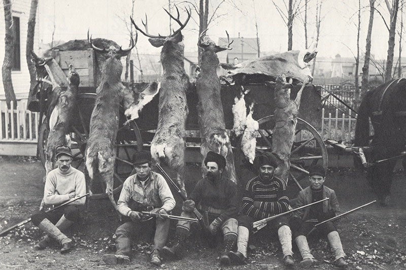 A black and white photo of deer hunters.