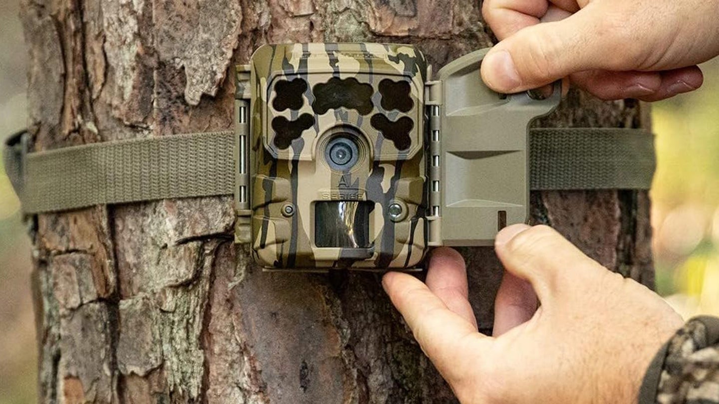 Hunter attaching a Moultrie trail camera to a tree
