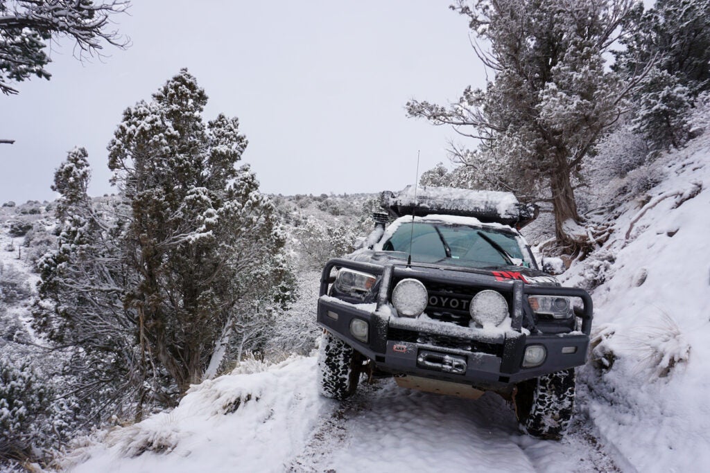 Truck descending a mountain in the snow on a winter trail.