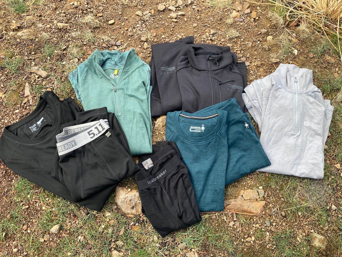 Assorted long johns and base layers spread out on grass