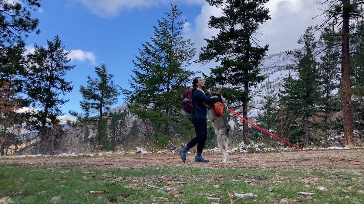 Female hiker wearing Smartwool Classic Merino wool base layers playing with dog