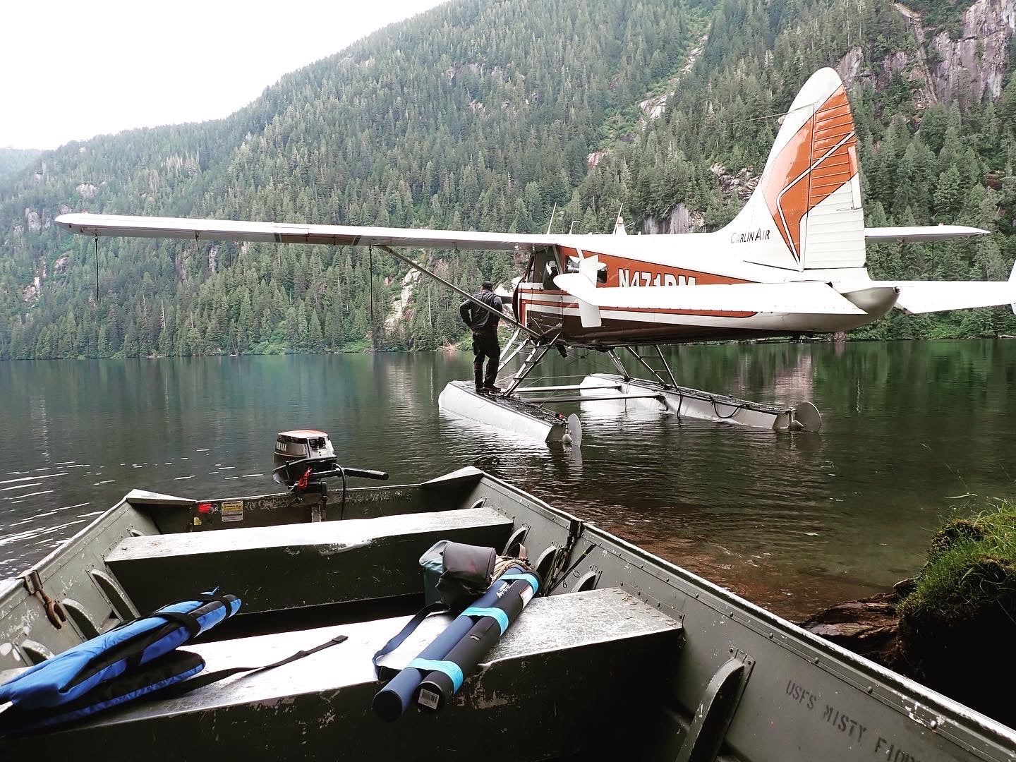 DeHaviland Beaver float plane docked in a lake.