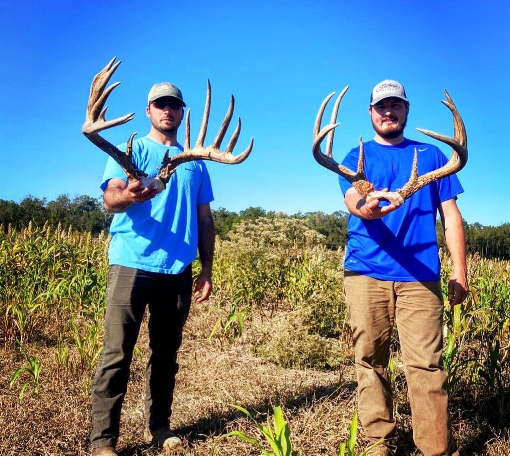 Hunters showing antlers to buck