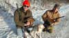 Andy Duffy holding a grouse with a dog and another hunter.