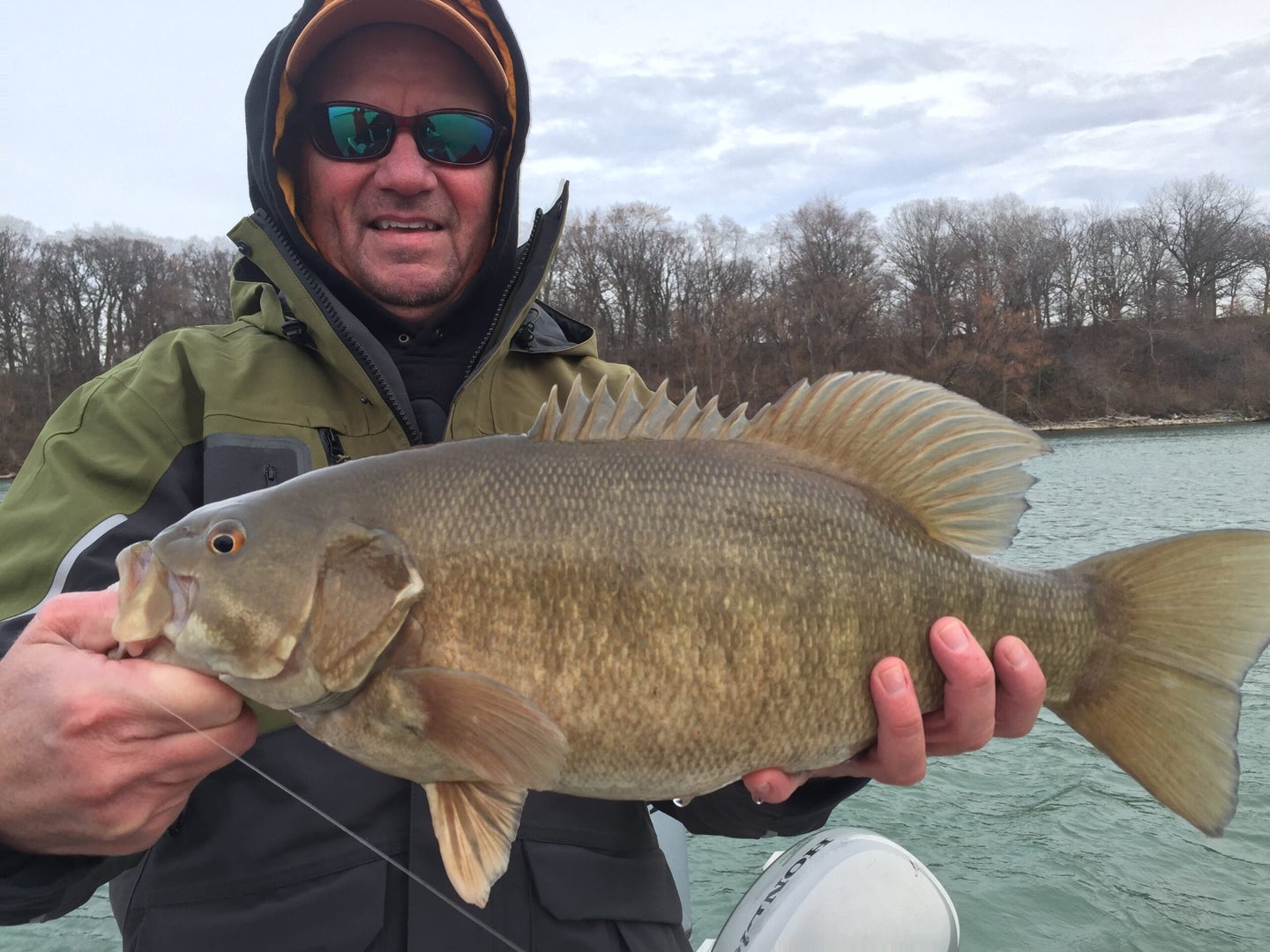 an angler catches a bass while winter smallmouth fishing