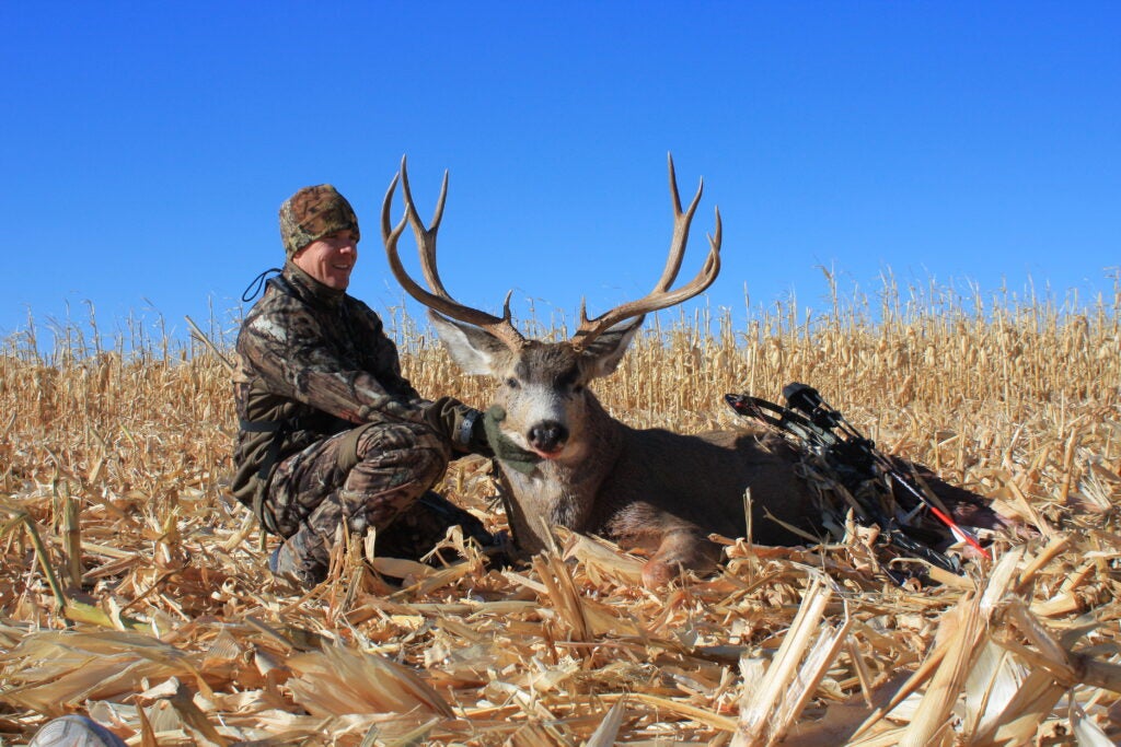 a hunter poses with a nice mule deer buck