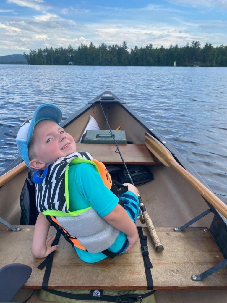 boy fishing for bass in a canoe