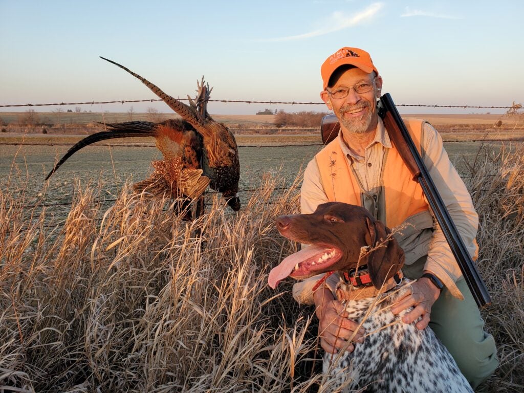 bird hunter and his dog with a pheasant