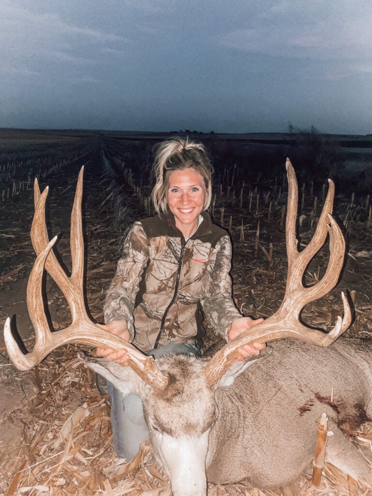woman poses with huge mule deer buck