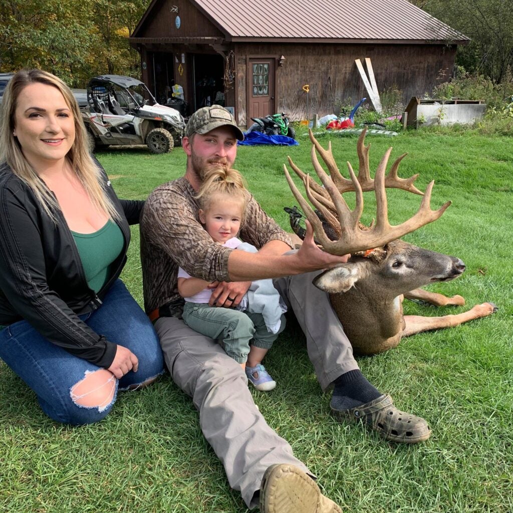 hunter and family pose with big whitetail buck