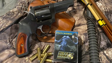 a photo of a handgun with hunting gear