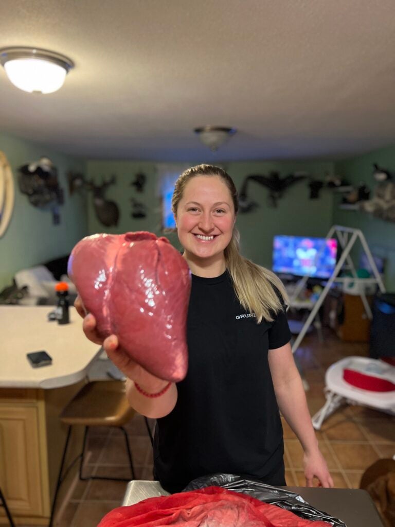 Blond woman poses with caribou heart