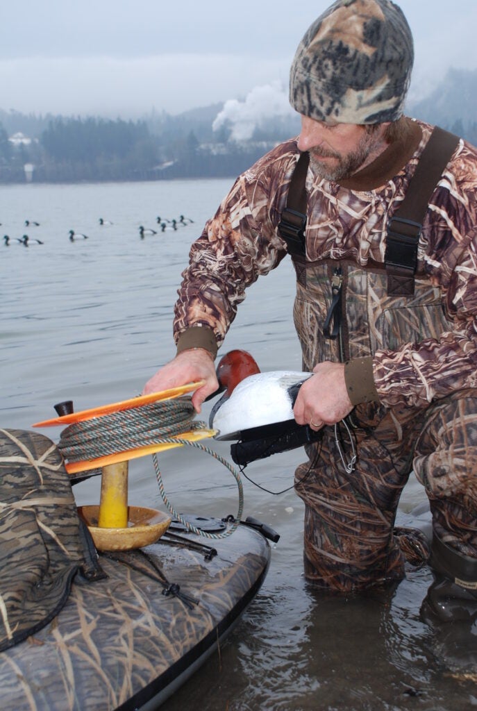 Hunter rigging diver duck decoys from a small boat.