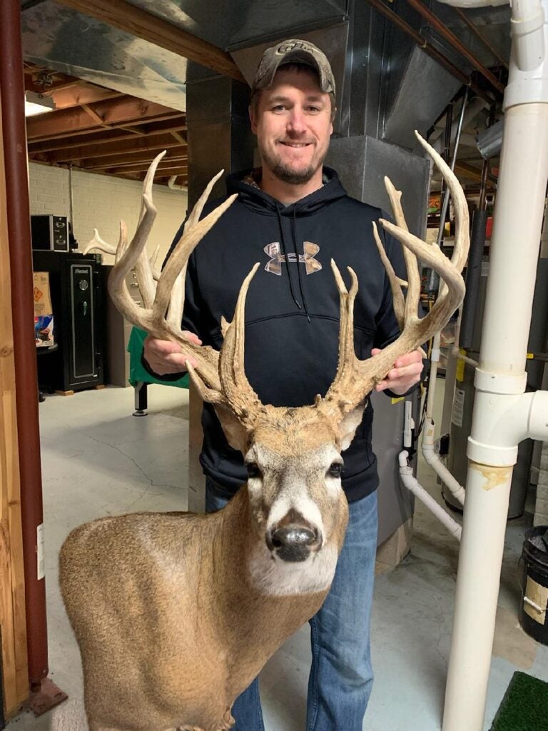 hunter with whitetail buck mount