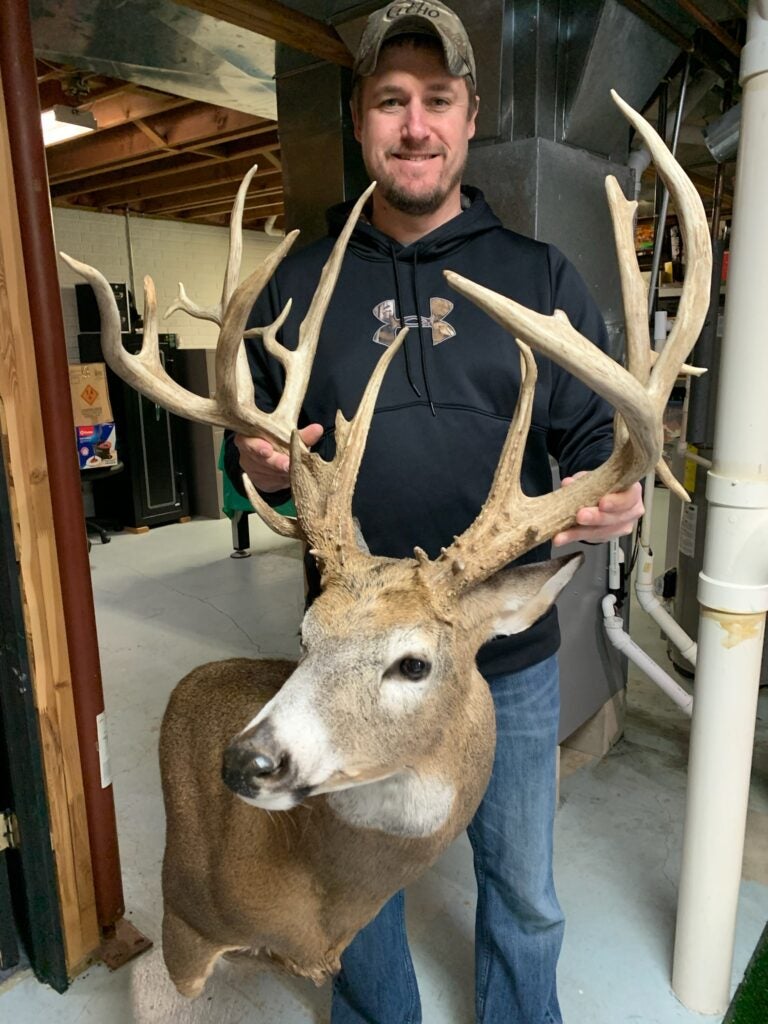 photo of hunter with whitetail buck mount