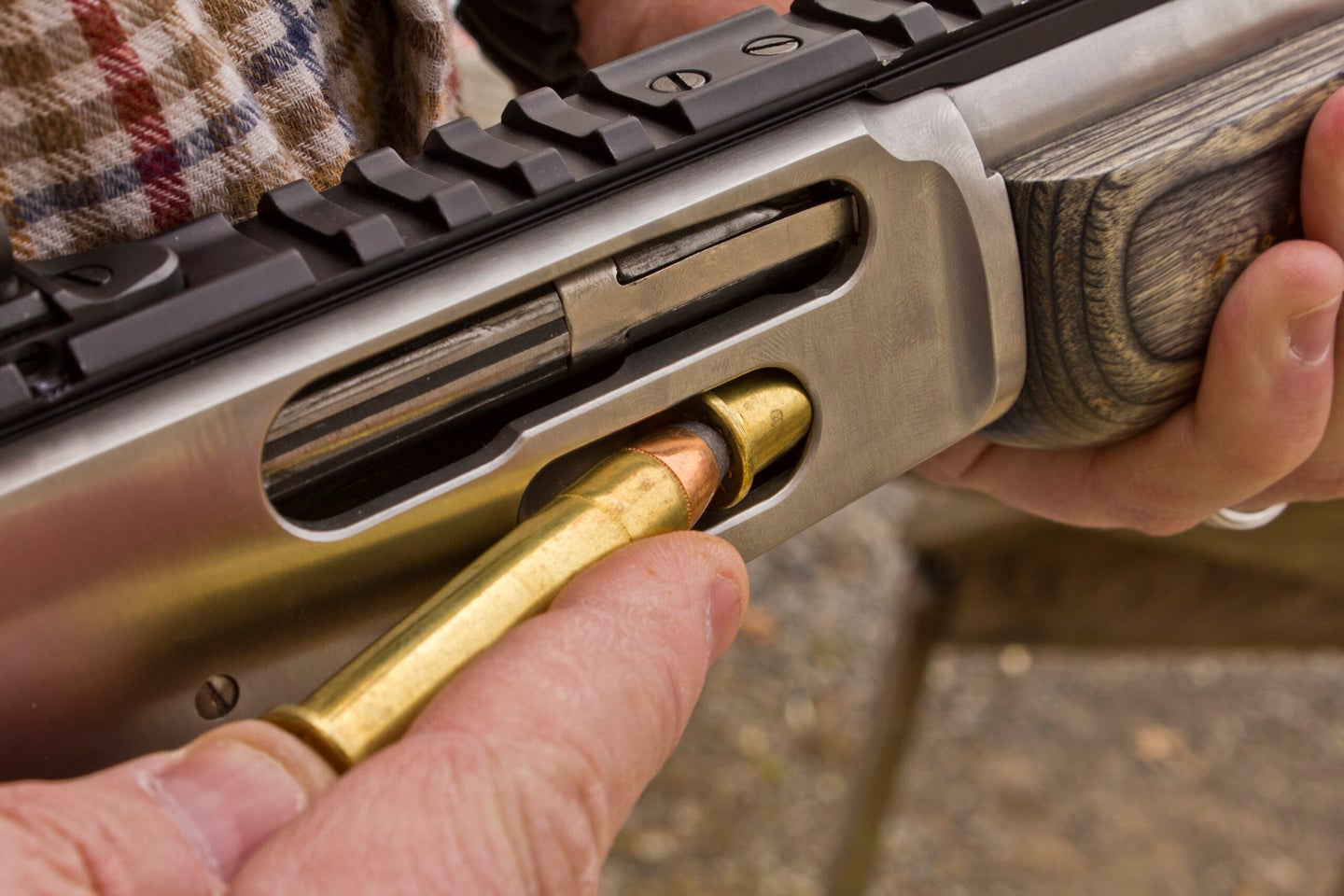 Loading a cartridge into a lever-action rifle.