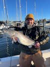 man holds large speckled trout at dock