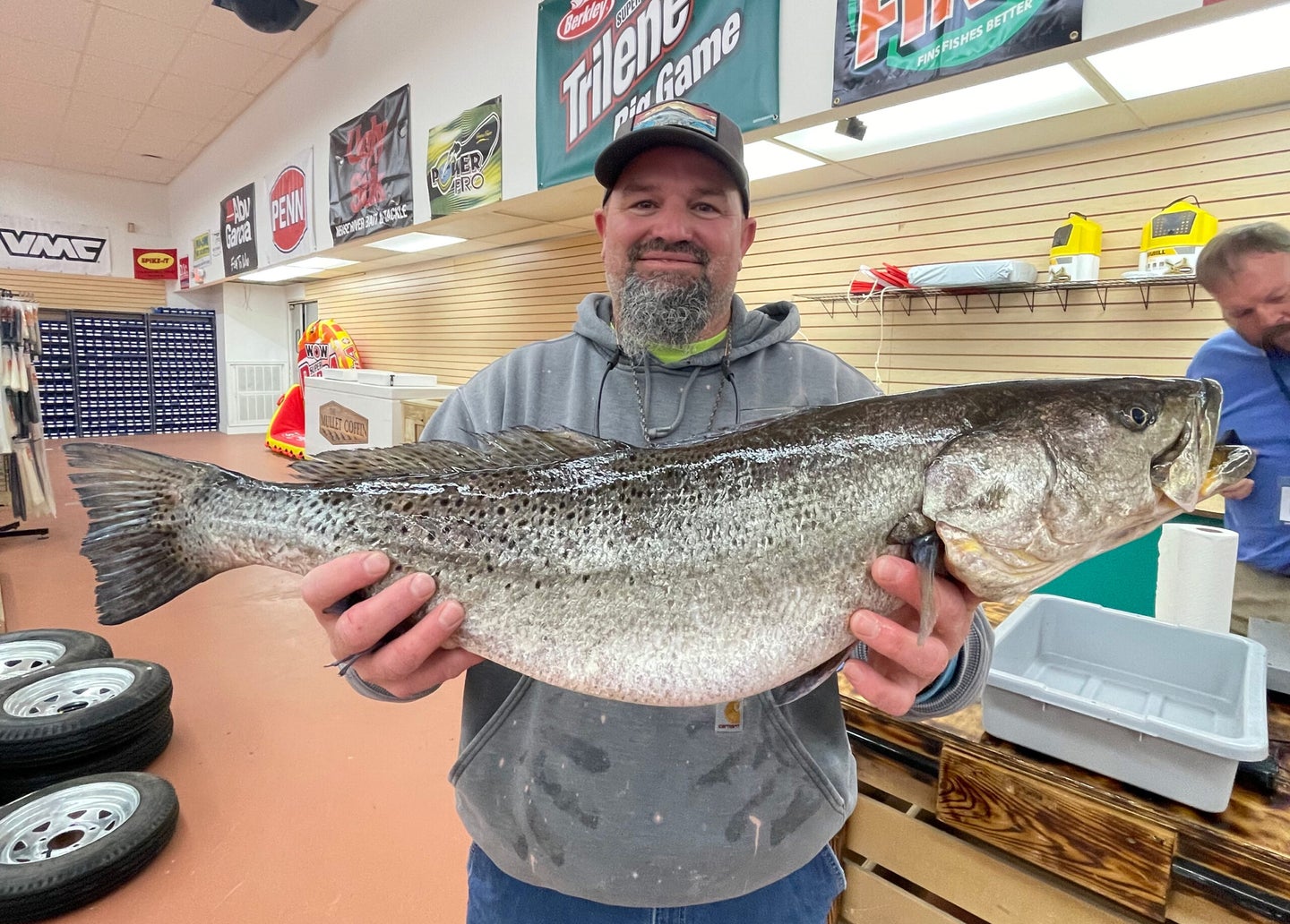 man holds new state record speckled trout