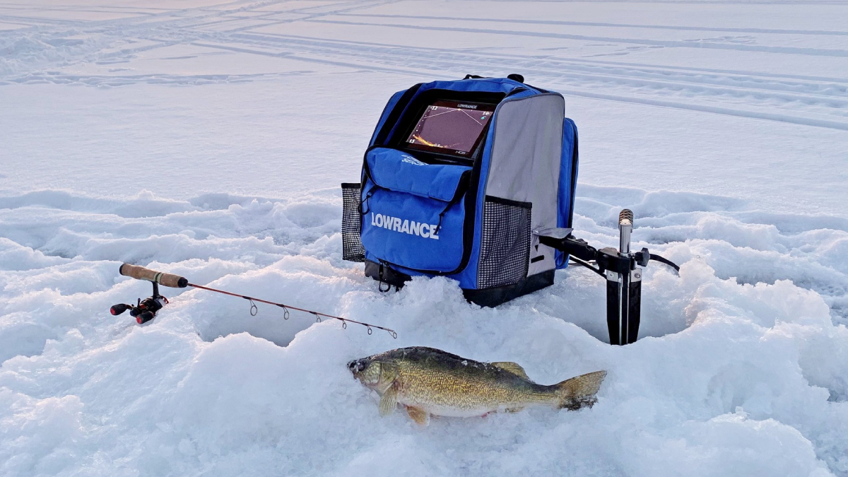 Lowrance fish finder for ice fishing sitting on frozen water with rod and reel