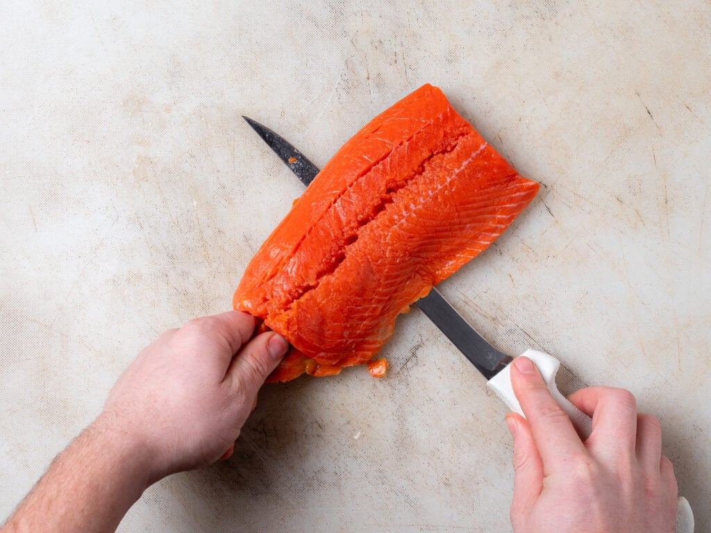The Dexter Outdoors SOFGRIP 8" Flexible Fillet Knife cutting through salmon
