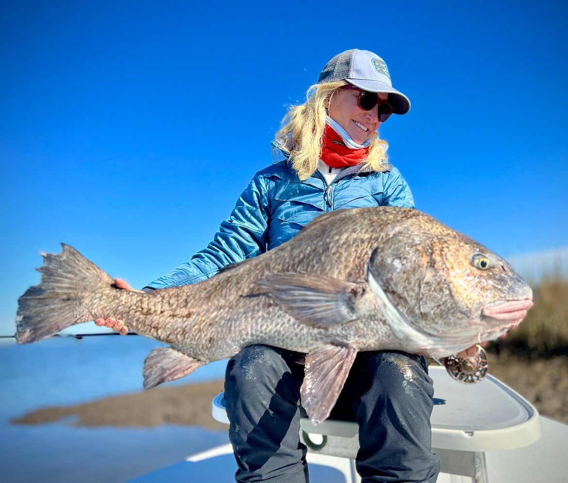 woman holds large black drum for photo