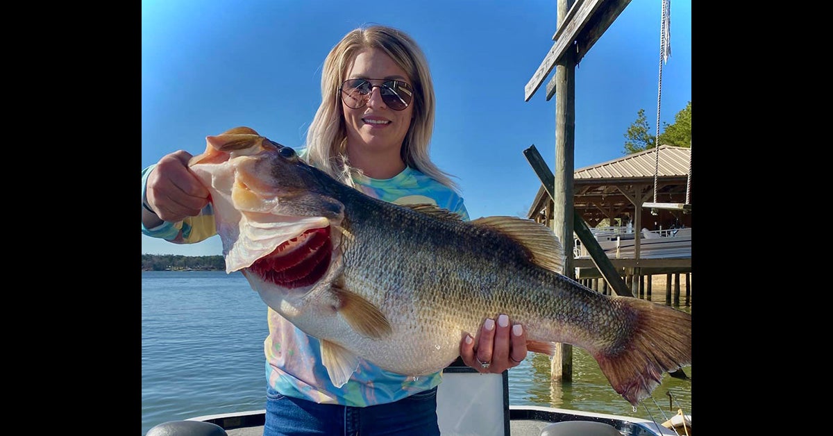woman holds large bass