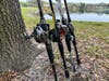 Baitcaster rod and reel combos lined up on grass