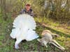 hunter poses with white turkey and coyote