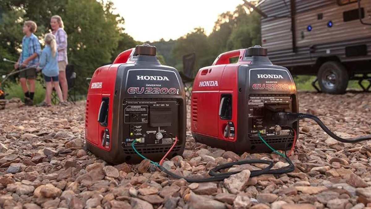 Pair of Honda EU2200ITAN Portable Inverter Generators sitting on ground at campsite