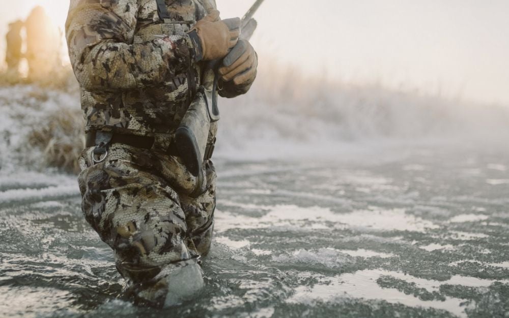 A hunter wades an icy river in the Sitka Delta Zip wader. 