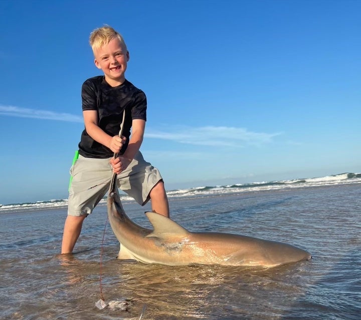 the boy poses with the little shark